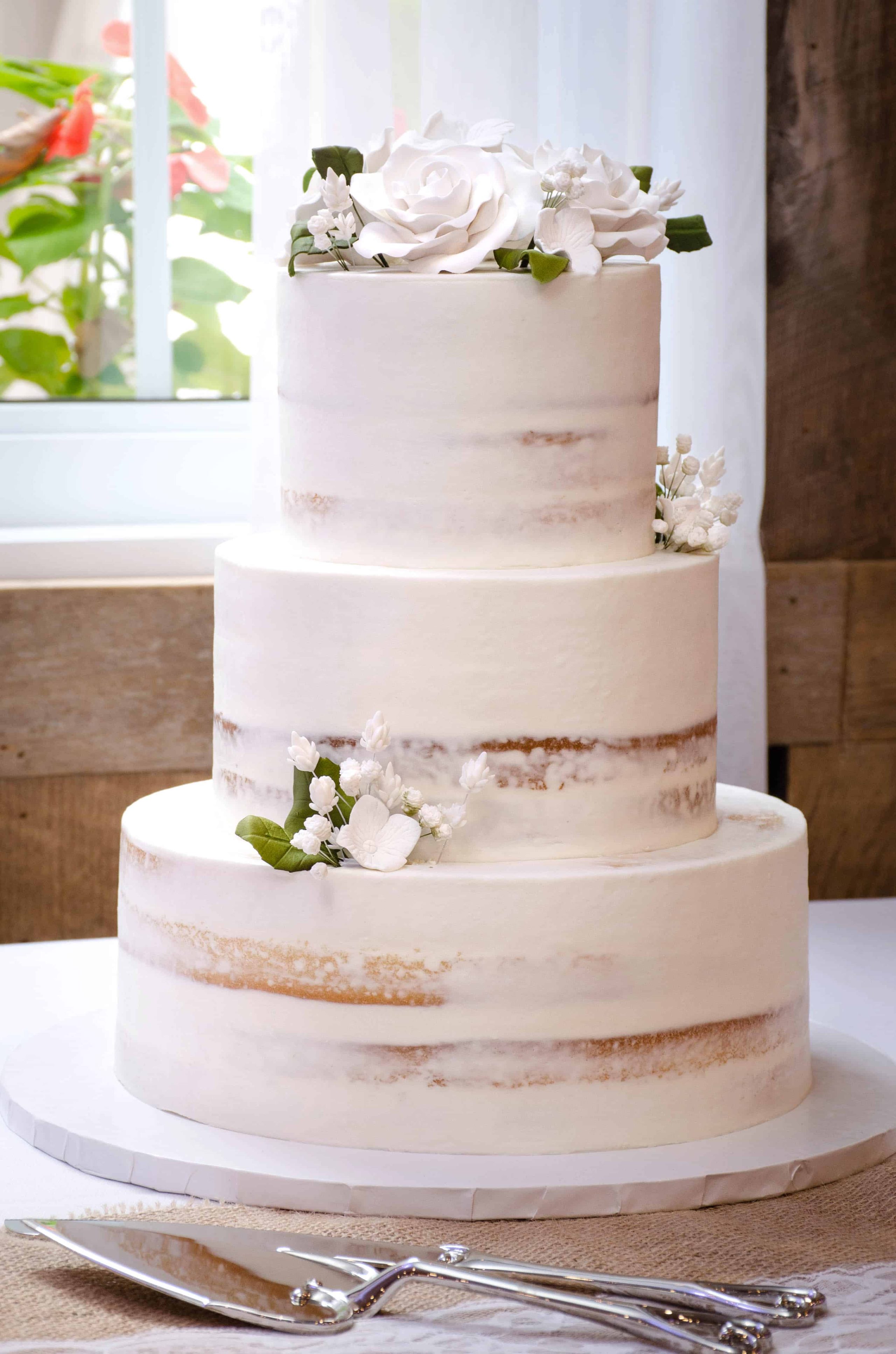 The Bride And Groom Cut Their Beautifully Decorated Naked Wedding Cake